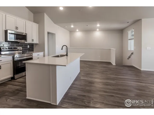 a view of kitchen with stainless steel appliances granite countertop a sink and cabinets