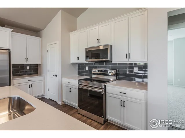 a kitchen with appliances a sink and cabinets