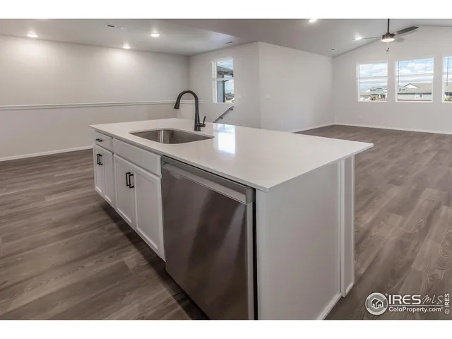 a kitchen with a sink and wooden floor