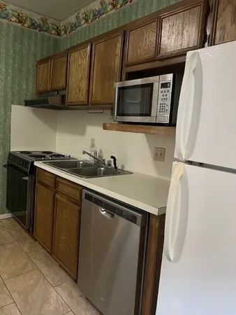 a kitchen with stainless steel appliances a refrigerator a microwave a sink and cabinets