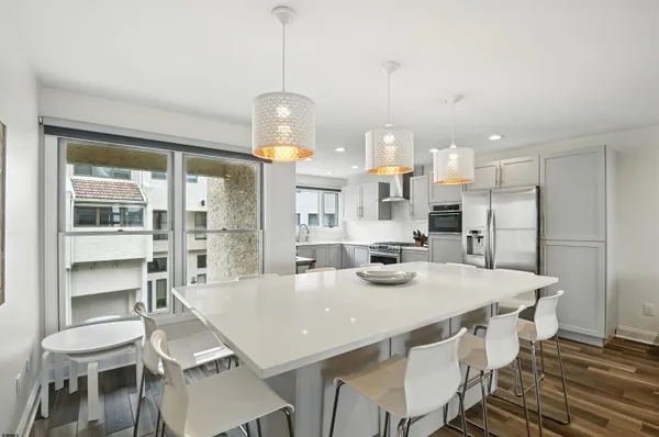 a kitchen with stainless steel appliances a table chairs and wooden floor