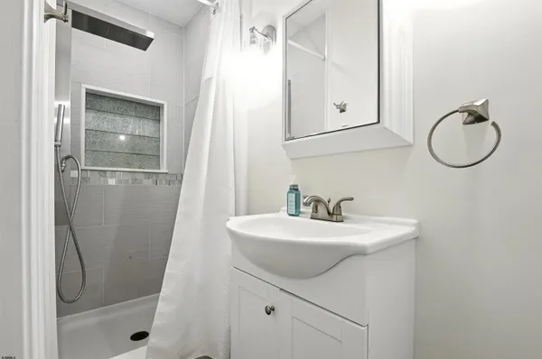 a bathroom with a sink a mirror a vanity and a shower