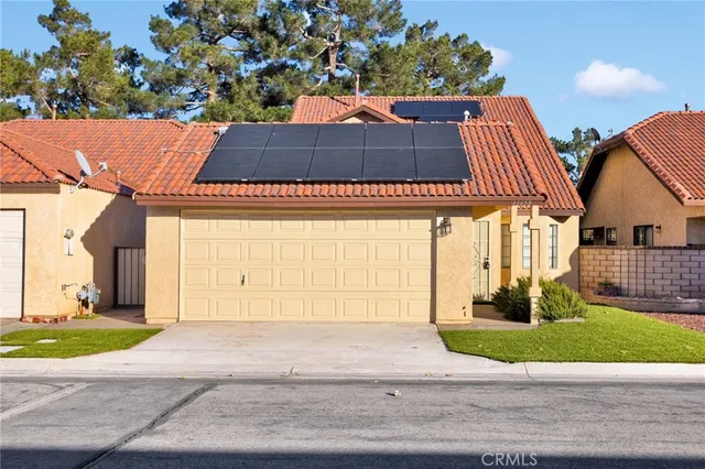 a front view of a house with a yard and potted plants