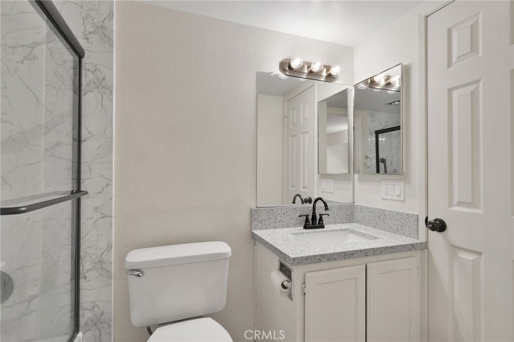 11659 Pepper Lane Apple Valley, CA 92308 - Photo 19 of 50 a bathroom with a toilet a sink and mirror