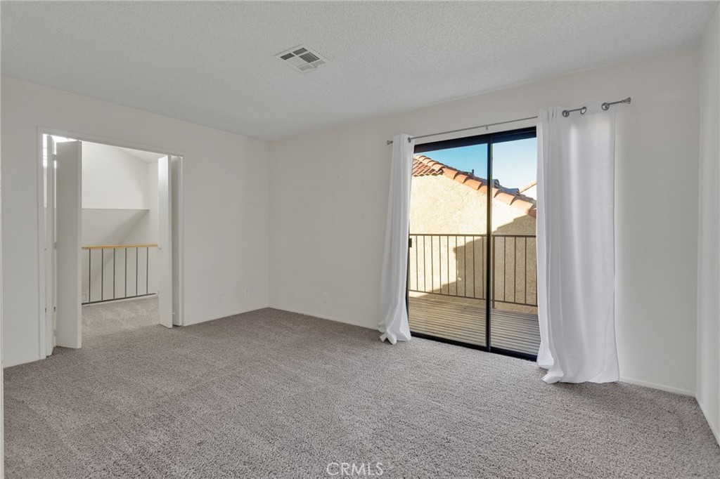 11659 Pepper Lane Apple Valley, CA 92308 - Photo 25 of 50 an empty room with sliding glass door and mountain view
