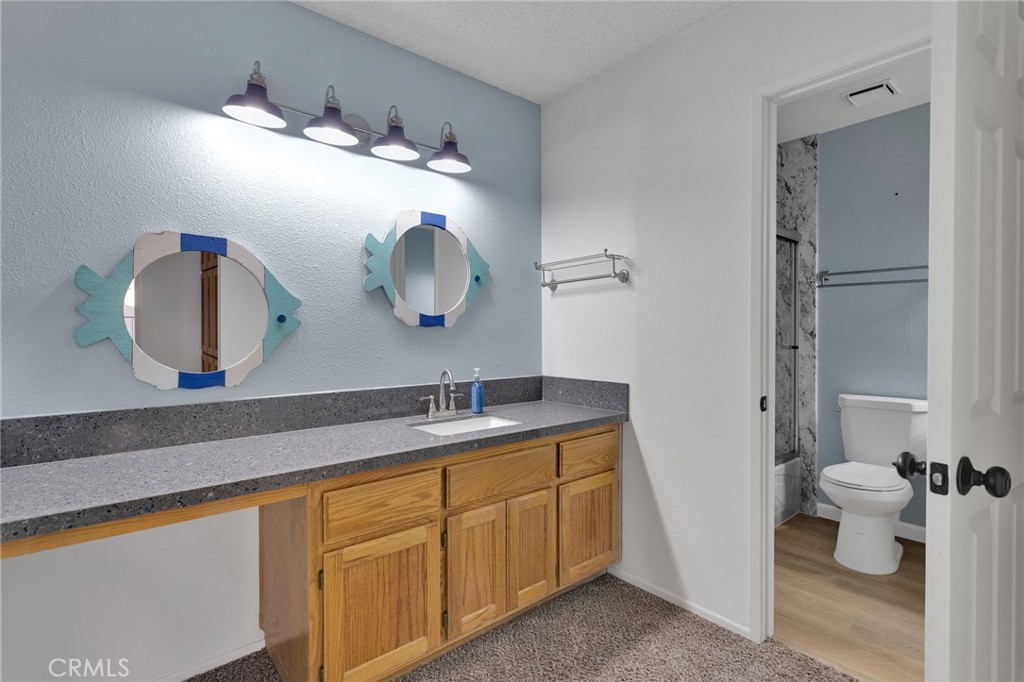 11659 Pepper Lane Apple Valley, CA 92308 - Photo 31 of 50 a bathroom with a granite countertop sink and a mirror