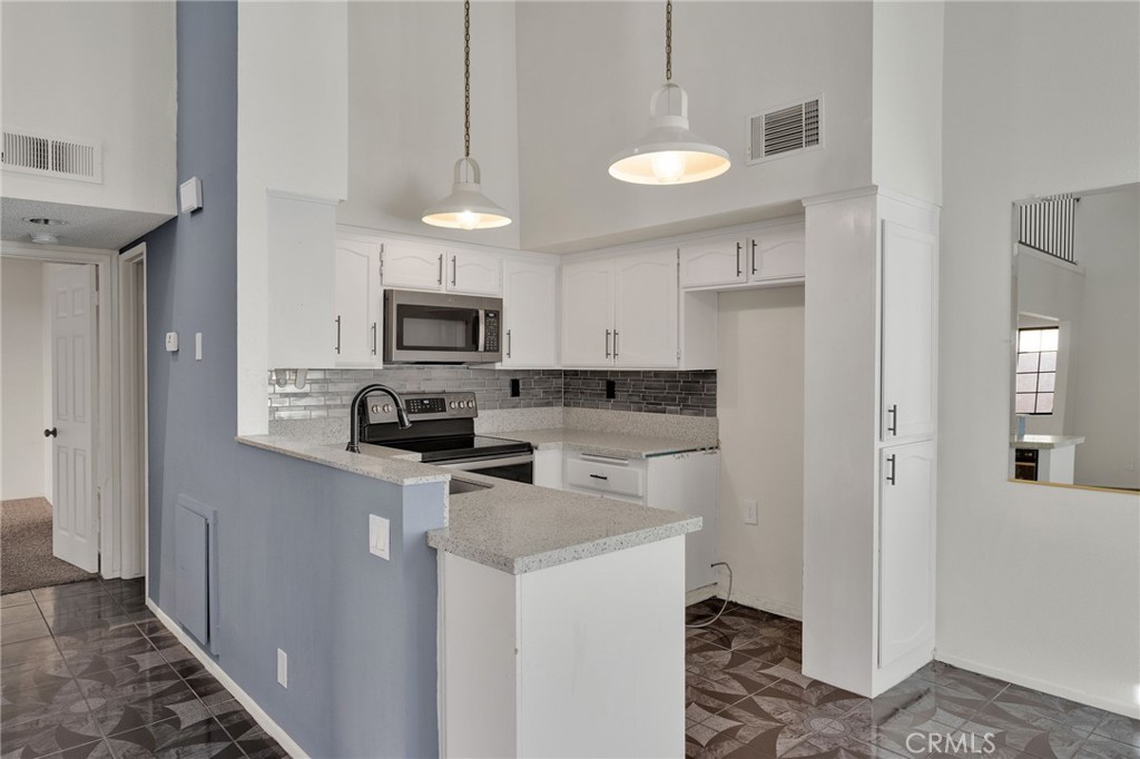 11659 Pepper Lane Apple Valley, CA 92308 - Photo 10 of 50 a kitchen with stainless steel appliances granite countertop a refrigerator stove microwave and sink