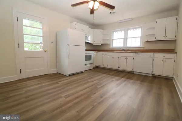 a kitchen with granite countertop white cabinets and white appliances