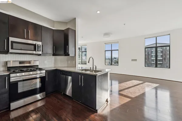 a kitchen with stainless steel appliances kitchen island granite countertop a stove a sink and a microwave