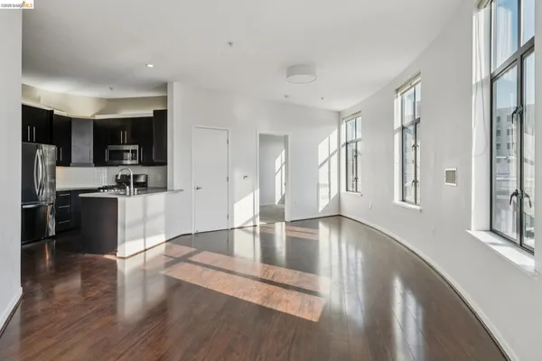a kitchen with stainless steel appliances granite countertop a refrigerator a sink a stove and oven with wooden floor