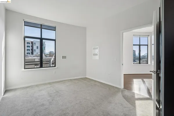 an empty room with windows and closet