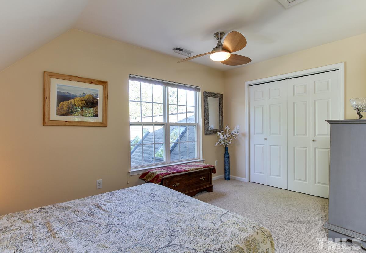 225 Cooke Street Raleigh, NC 27601 - Photo 14 of 24 a bedroom with a bed and a chandelier