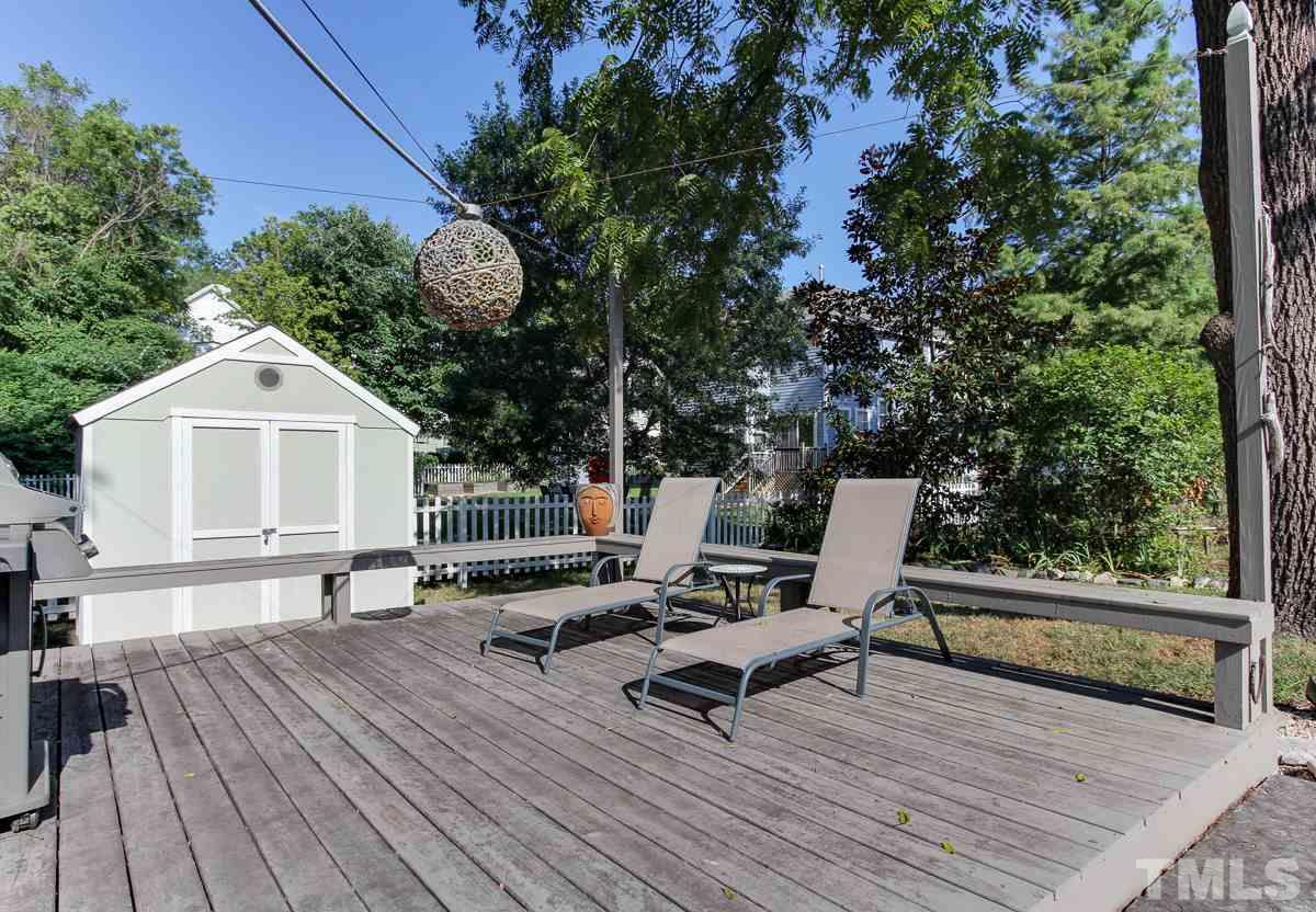 225 Cooke Street Raleigh, NC 27601 - Photo 21 of 24 a view of a roof deck with table and chairs with wooden floor and fence