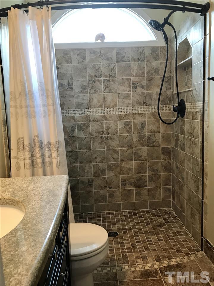 225 Cooke Street Raleigh, NC 27601 - Photo 10 of 24 a bathroom with a granite countertop sink a toilet and shower