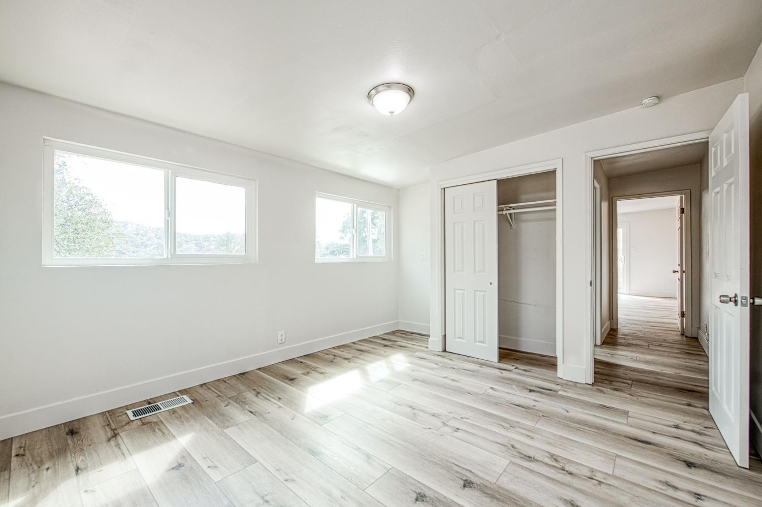 29531 Morgan Canyon Road Prather, CA 93651 - Photo 17 of 42 a view of an empty room with wooden floor and a window