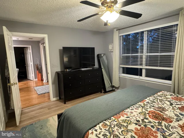 a bedroom with a bed and a flat tv screen on dresser
