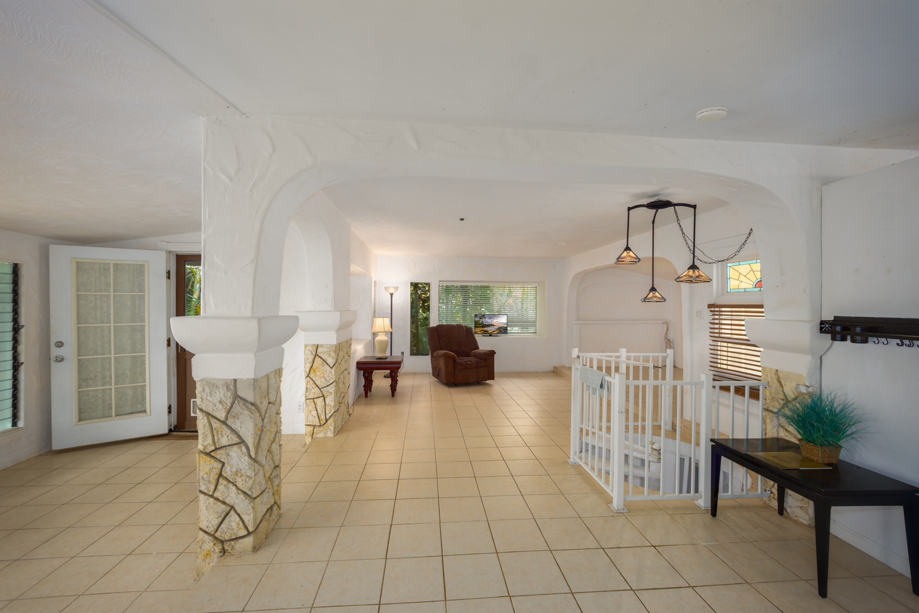 84-5125 Hawaiʻi Belt Road Captain Cook, HI 96704 - Photo 9 of 27 a living room with furniture and a chandelier