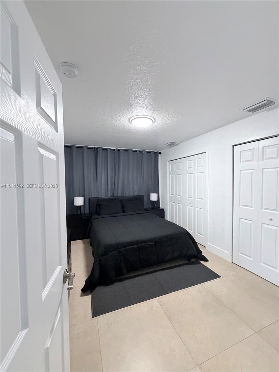 13261 Southwest 260th Terrace Homestead, FL 33032 - Photo 19 of 36 a living room with a couch and a dresser