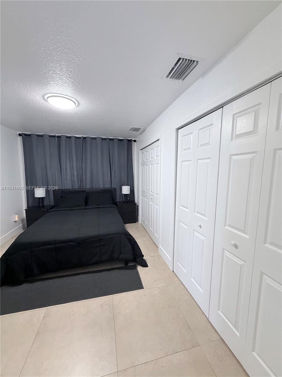 13261 Southwest 260th Terrace Homestead, FL 33032 - Photo 21 of 36 a bedroom with a bed and a dresser