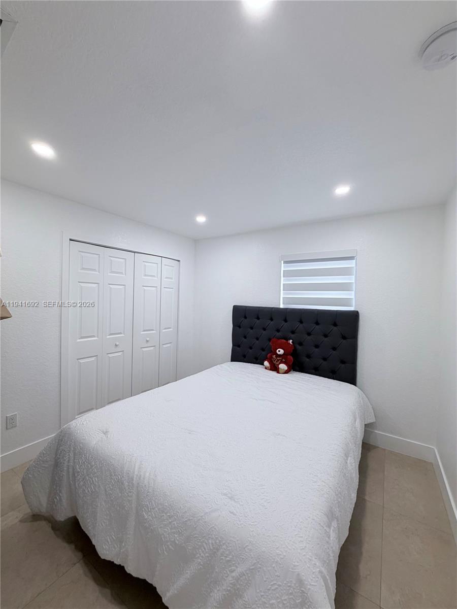 13261 Southwest 260th Terrace Homestead, FL 33032 - Photo 28 of 36 a bedroom with a large bed and a fireplace