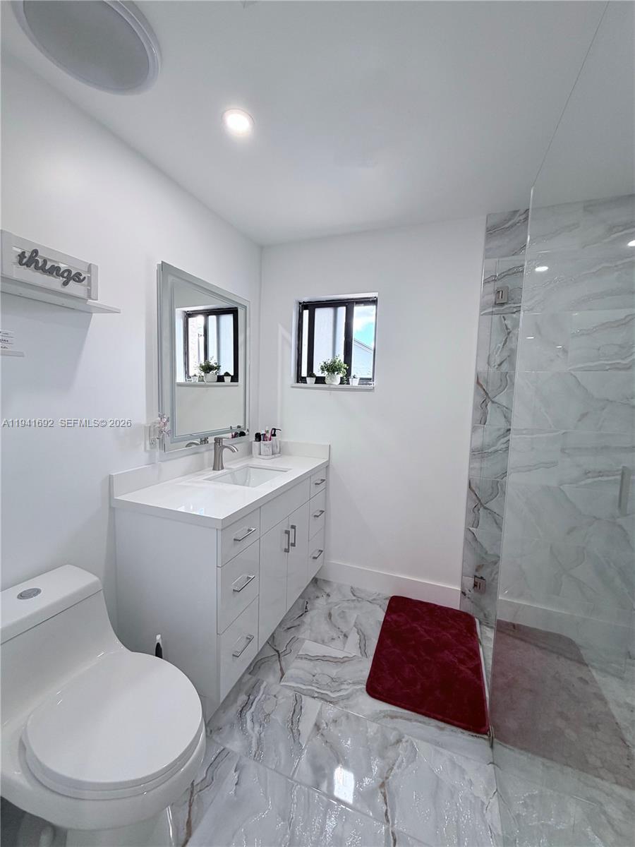 13261 Southwest 260th Terrace Homestead, FL 33032 - Photo 34 of 36 a bathroom with a toilet sink and mirror