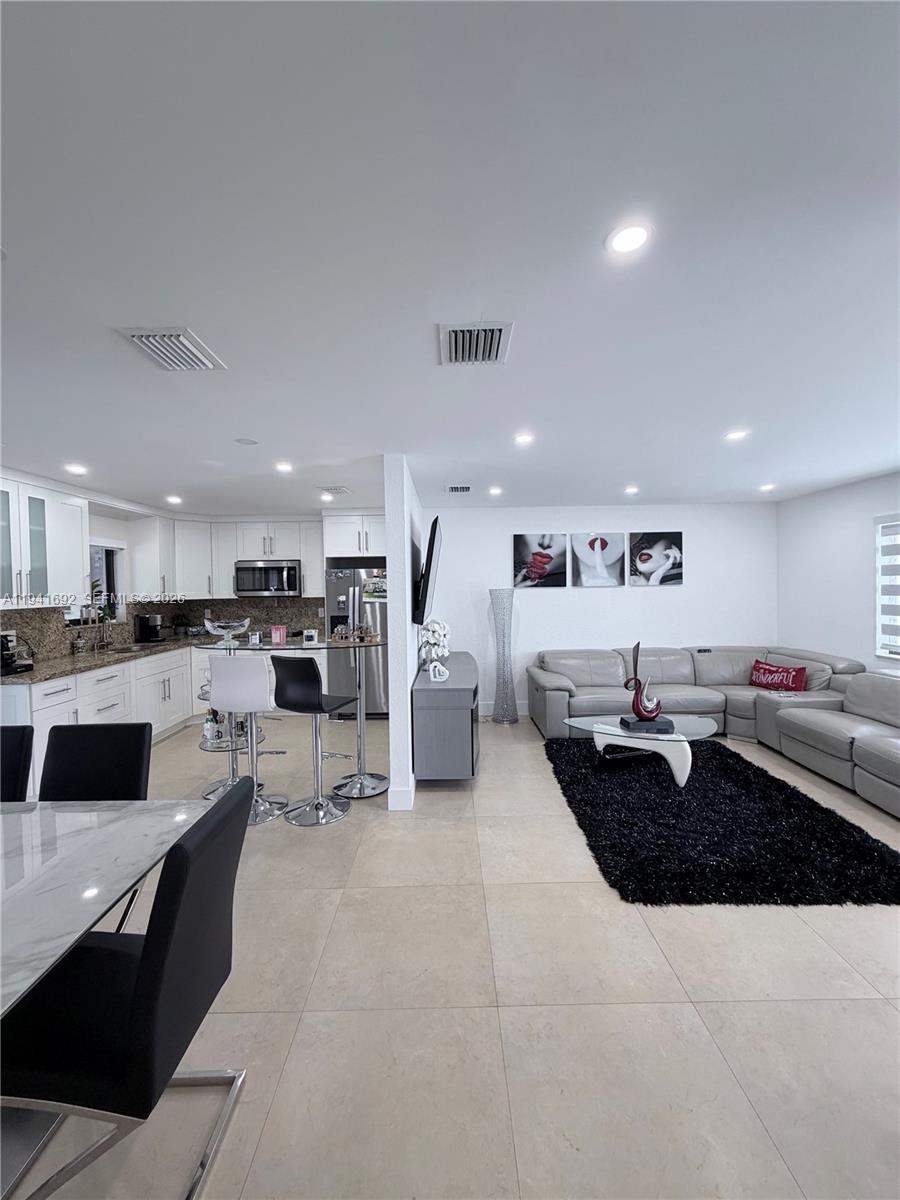13261 Southwest 260th Terrace Homestead, FL 33032 - Photo 36 of 36 a living room with stainless steel appliances kitchen island granite countertop a living room and white cabinets