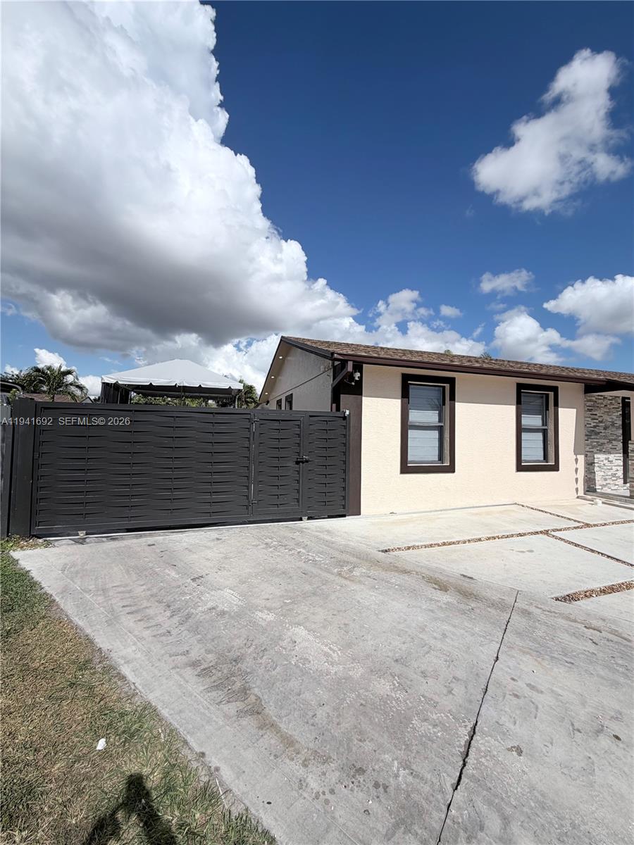 13261 Southwest 260th Terrace Homestead, FL 33032 - Photo 6 of 36 a front view of a house with a yard