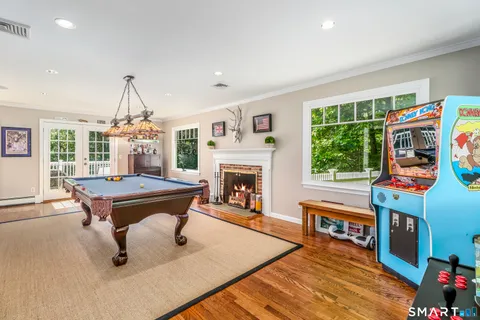 a living room with furniture a fireplace and a floor to ceiling window