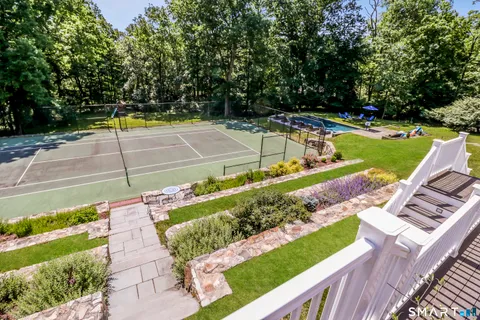 a view of a tennis ground with large trees