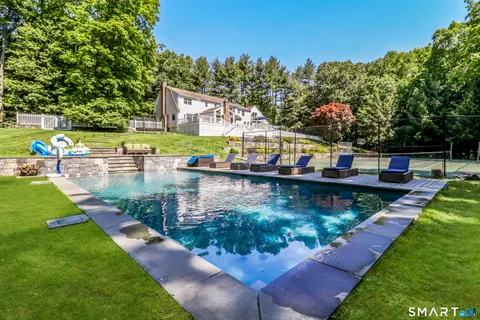 an aerial view of a house with swimming pool a yard and lake view