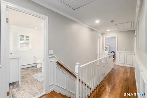a view of a hallway with wooden floor and staircase