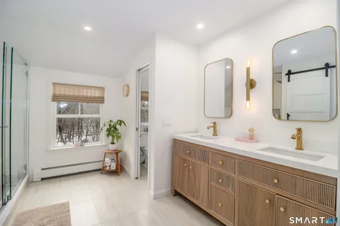 a spacious bathroom with double vanity a mirror a vanity and a bathtub