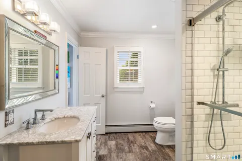 a bathroom with a granite countertop sink toilet and shower