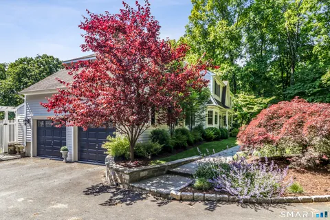 a front view of a house with a yard and tree s