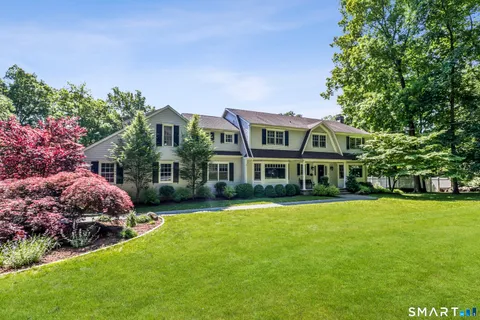a front view of building with yard and trees