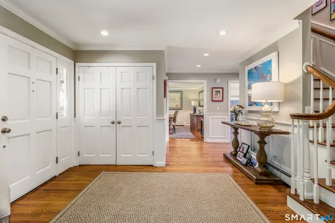 a view of a kitchen with kitchen island stainless steel appliances wooden floor and living room view