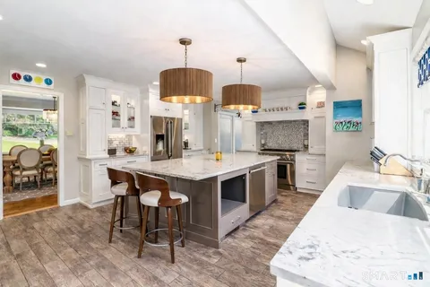 a kitchen with a sink stove and wooden floor