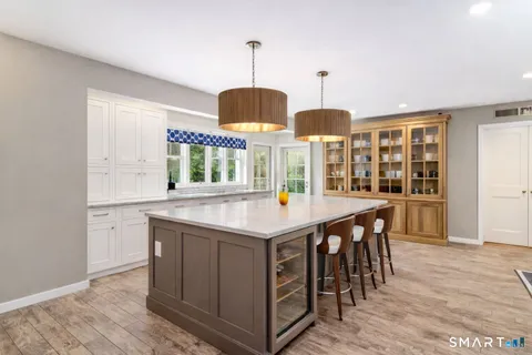 a kitchen with stainless steel appliances granite countertop wooden floor and chandelier