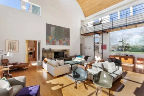 a living room with furniture a fireplace and a floor to ceiling window