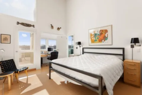 a bed room with a bed and a chair