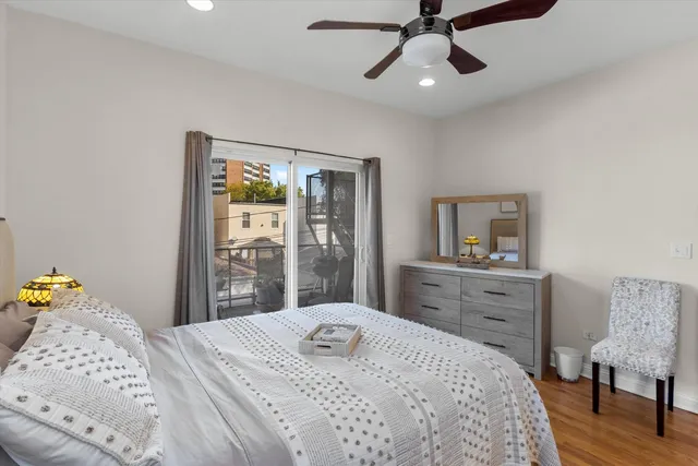 a bedroom with a bed and dresser with mirror