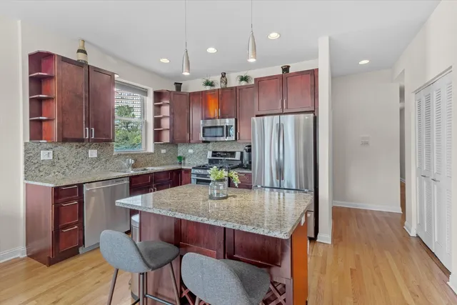 a kitchen with kitchen island a large counter top space appliances and cabinets