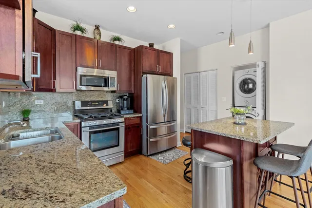 a kitchen with stainless steel appliances granite countertop a refrigerator stove microwave and sink