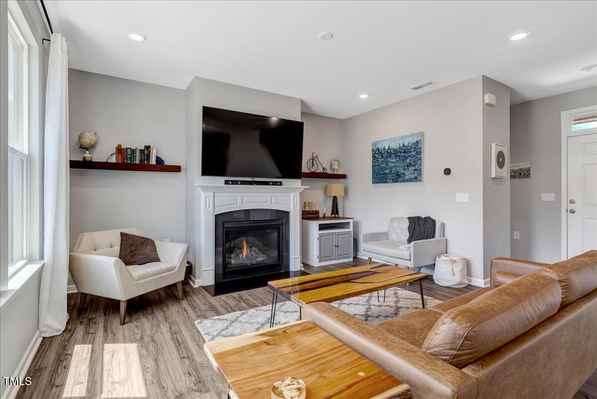 45 Iris Drive Youngsville, NC 27596 - Photo 10 of 35 a living room with furniture a flat screen tv and a fireplace