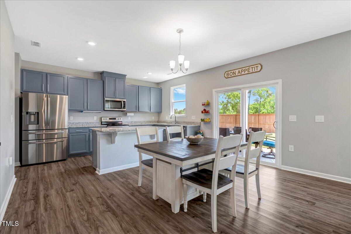 45 Iris Drive Youngsville, NC 27596 - Photo 6 of 35 a kitchen with stainless steel appliances a dining table chairs refrigerator and microwave