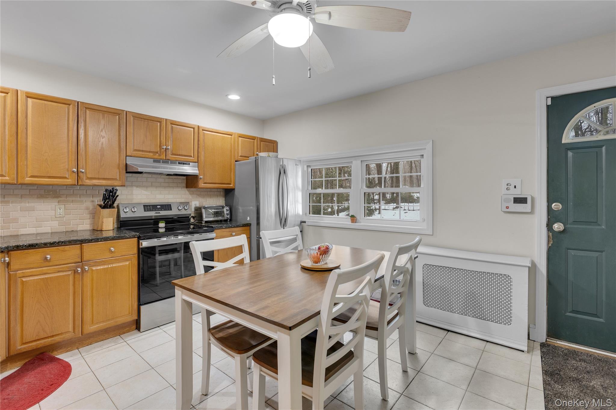 72 Daly Road East Northport, NY 11731 - Photo 9 of 18 a kitchen with granite countertop stainless steel appliances a stove a sink a refrigerator cabinets and dining table