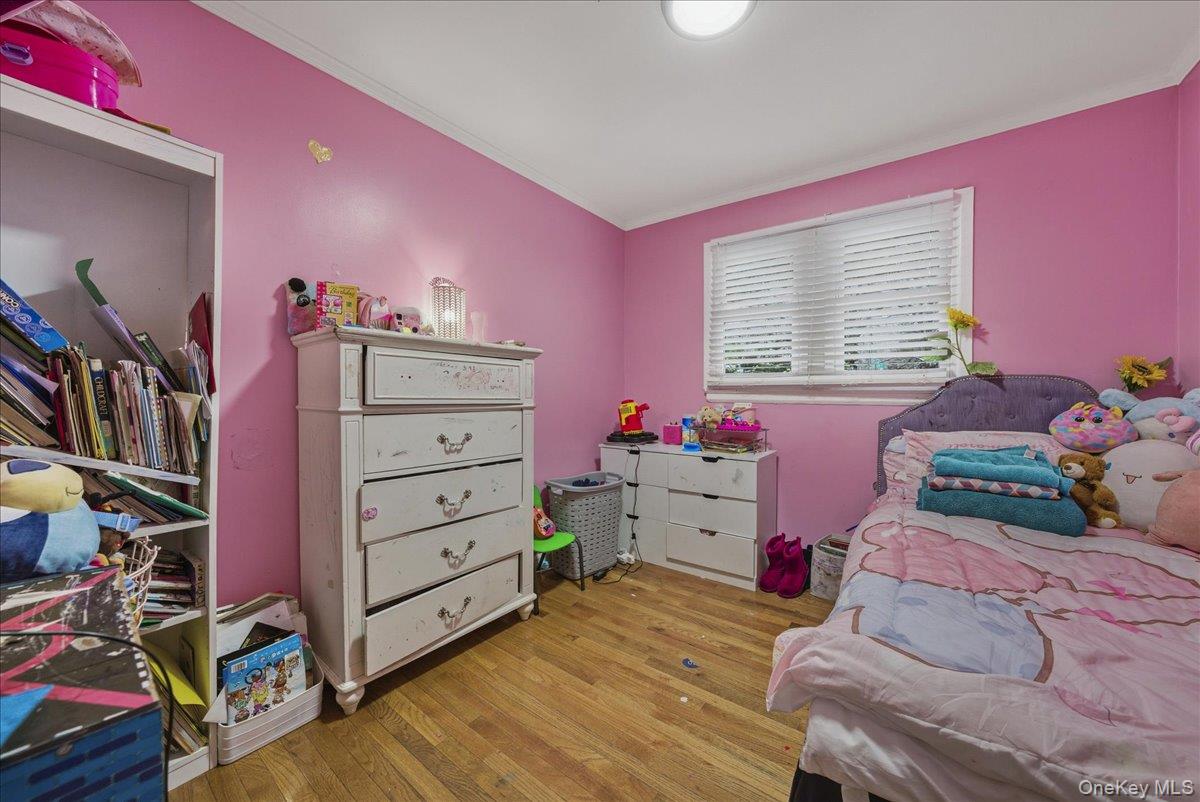 128-66 238th Street Queens, NY 11422 - Photo 10 of 25 a bedroom with a bed and wooden floor