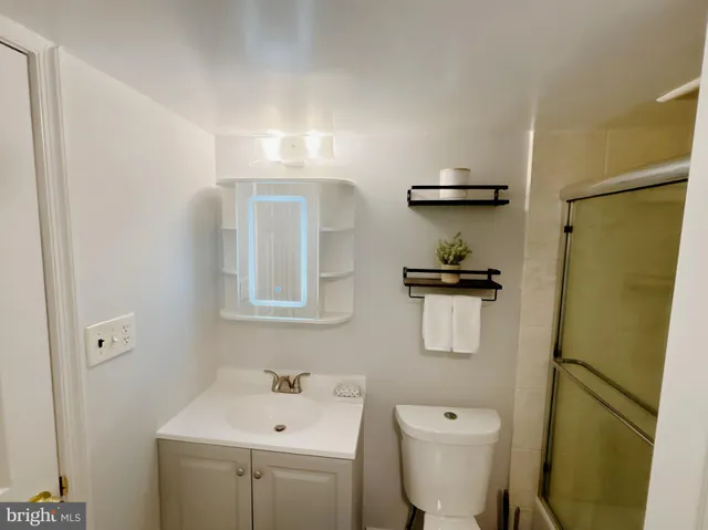 a bathroom with a sink a toilet and shower