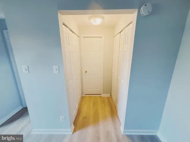 a view of a hallway with wooden floor