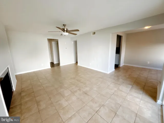 a view of an empty room with a ceiling fan